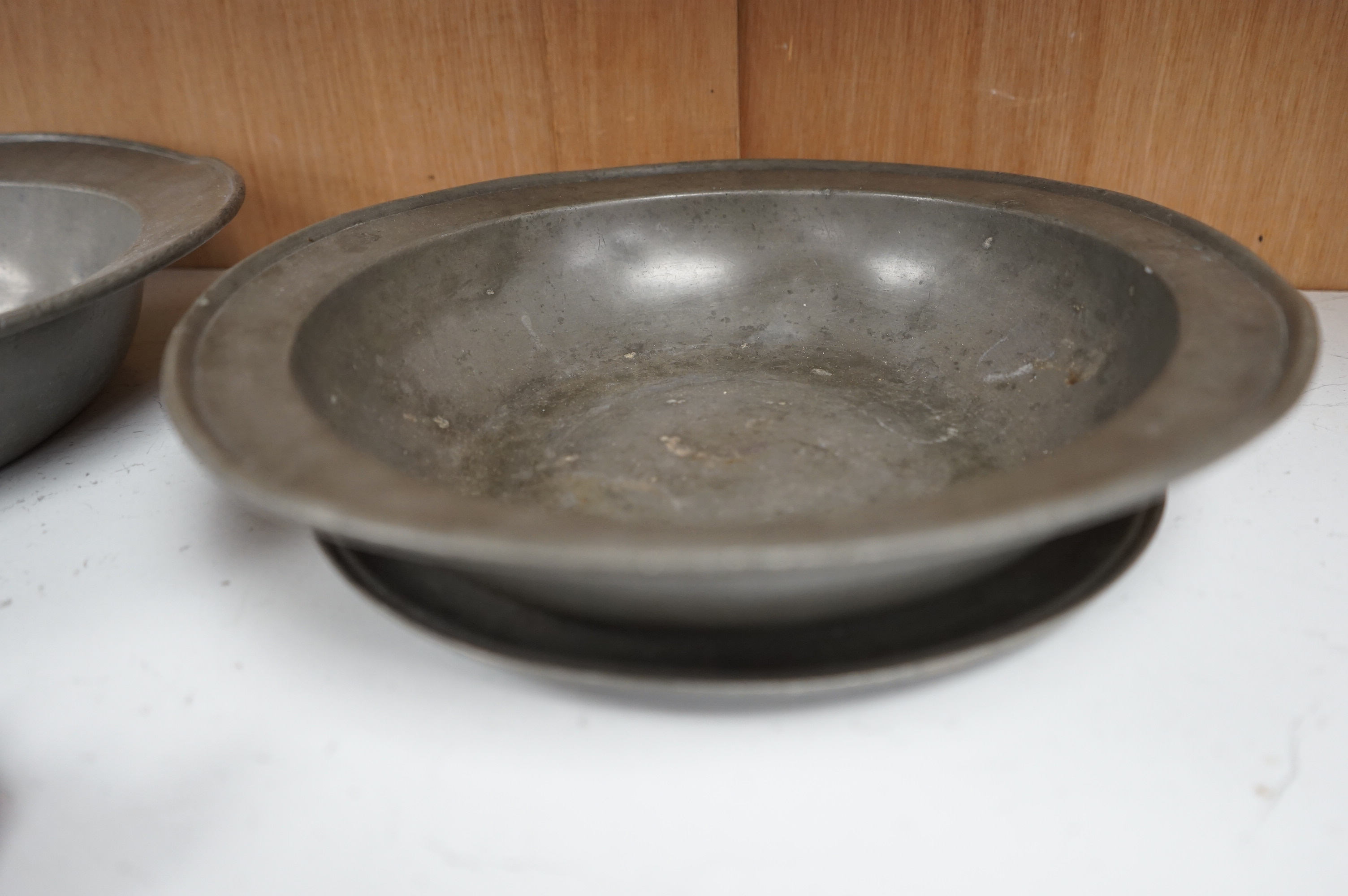 Two 18th century Dutch pewter bowls and a dish, largest 33cm high. Condition - fair, misshapen